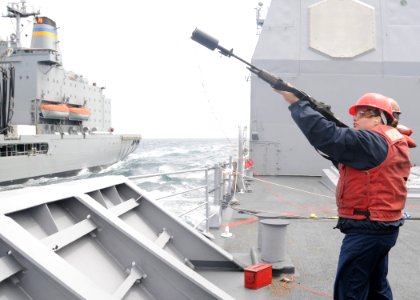 US Navy 100615-N-3327M-060 Fire Controlman 2nd Class Lacey Robertson, from Conroe, Texas, fires a shot line during a replenishment at sea with the Military Sealift Command fleet replenishment oiler USNS Guadaloupe (T-AO 200)