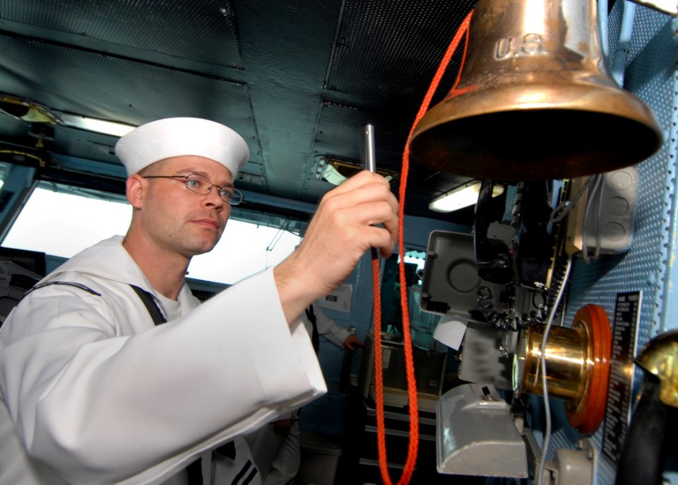 US Navy 100614-N-2013O-004 Boatswain's Mate 2nd Class Kenneth Stearly, from San Diego, strikes the ship's bell during sea and anchor detail aboard the aircraft carrier USS George Washington (CVN 73)