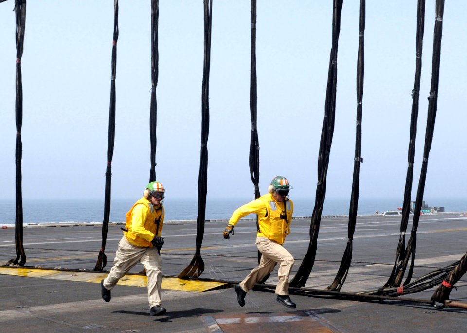 US Navy 100614-N-4236E-370 Flight deck officers run across the flight deck while participating in a barricade drill aboard the aircraft carrier USS Dwight D. Eisenhower (CVN 69)