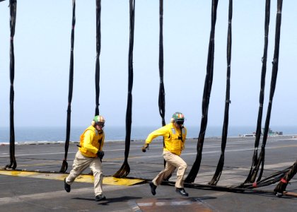 US Navy 100614-N-4236E-370 Flight deck officers run across the flight deck while participating in a barricade drill aboard the aircraft carrier USS Dwight D. Eisenhower (CVN 69)