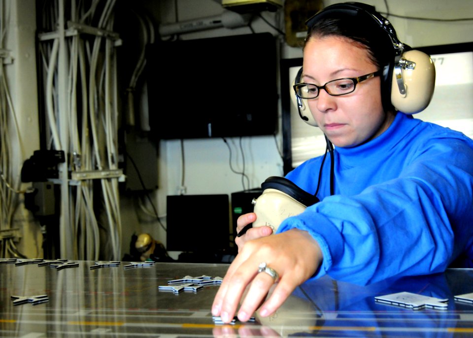 US Navy 100612-N-7908T-258 Aviation Boatswain's Mate (Handling) Airman Destiny C. Phillips moves models along the ship's Ouija board aboard USS George H.W. Bush (CVN 77)