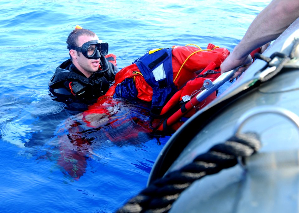 US Navy 100615-N-7908T-770 earch and rescue swimmer Interior Communications Electrician 2nd Class Brandon E. Fox places Oscar into a litter during a man overboard rescue drill