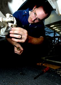 US Navy 100612-N-7908T-034 Aviation Support Equipment Technician 3rd Class Trevor J. Neuroth performs maintenance on a tow tractor aboard USS George H.W. Bush (CVN 77)
