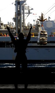 US Navy 100616-N-4135M-088 Boatswain's Mate 3rd Class Shavanda Stephens signals to Sailors aboard the Nimitz-class aircraft carrier USS Harry S. Truman (CVN 75) of incoming supplies