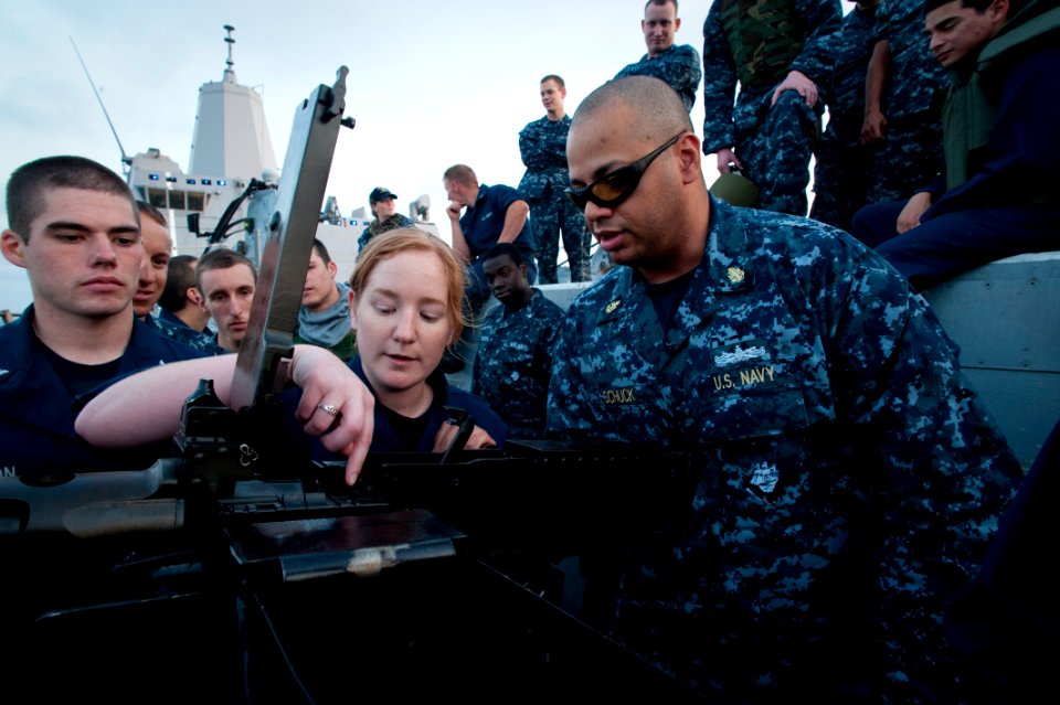 US Navy 100614-N-5319A-071 Chief Fire Controlman Job Schuck instructs Yeoman 3rd Class Diana Grams and other Sailors on the operations of a firing .50-caliber machine gun