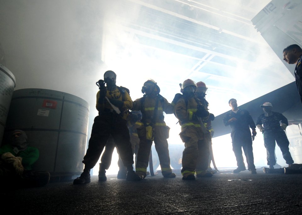 US Navy 100615-N-7191M-015 Hose team members fight a simulated fire during a general quarters drill in the hangar bay aboard USS George Washington (CVN 73)