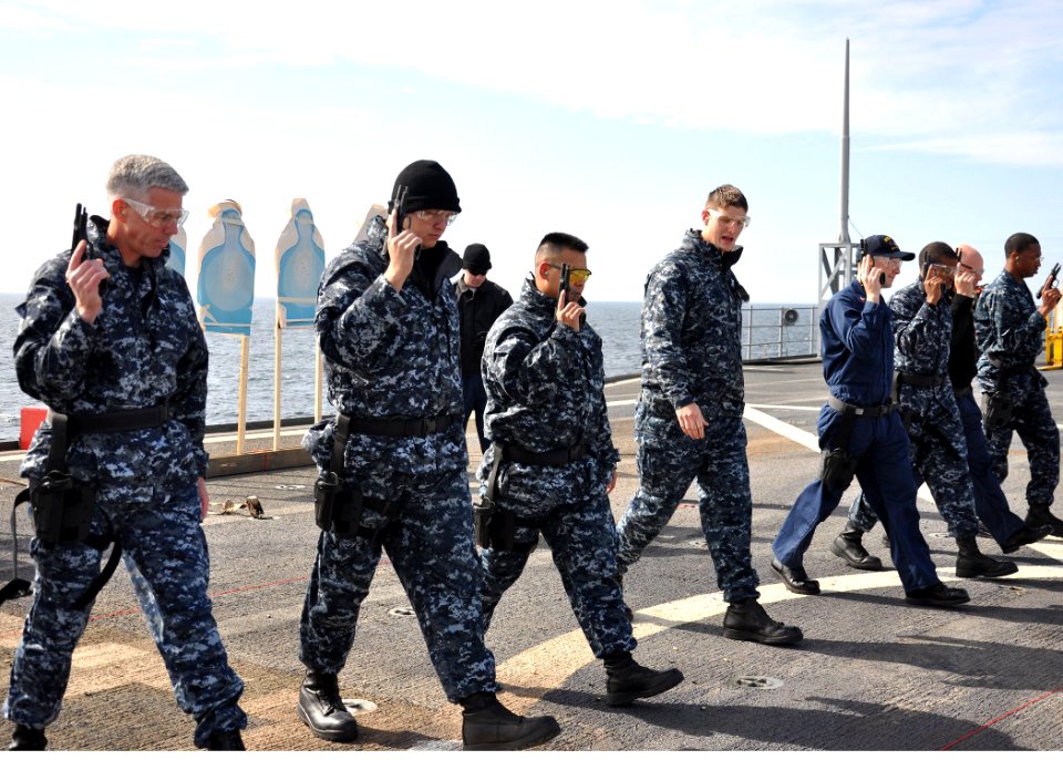 US Navy 100614-N-5483N-206 Sailors walk to the seven yard line marker as they hold a 9mm pistol in the administrative carry position during the Navy Handgun Qualification Course
