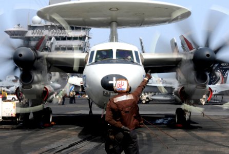 US Navy 100614-N-4236E-098 Aviation Electronics Technician Airman Thomas Buhlinger directs an E-2C Hawkeye assigned to the Bluetails of Airborne Early Warning Squadron (VAW) 121 to start its engines aboard the aircraft carrier