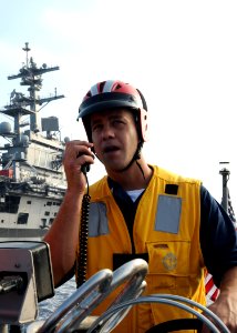 US Navy 100615-N-7908T-260 Boatswain's Mate 2nd Class Trevor J. Ball communicates to the bridge during a man overboard recovery drill