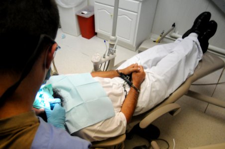 US Navy 100617-N-7456N-152 The Joint Medical Group dental officer provides dental treatment to a detainee at the detention hospital at Joint Task Force Guantanamo photo