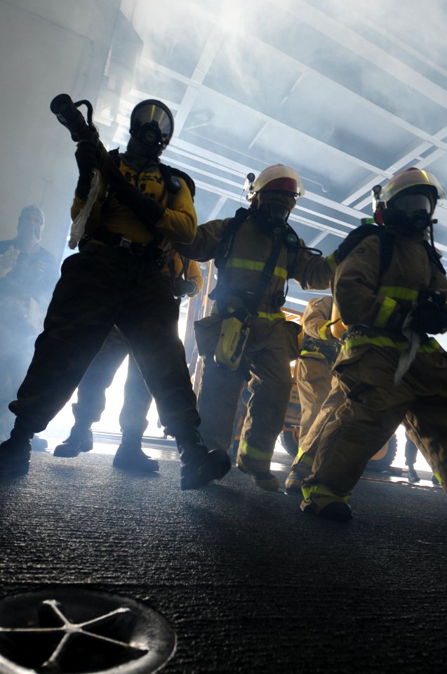 US Navy 100615-N-7191M-012 Hose team members fight a simulated fire during a general quarters drill in the hangar bay aboard USS George Washington (CVN 73)
