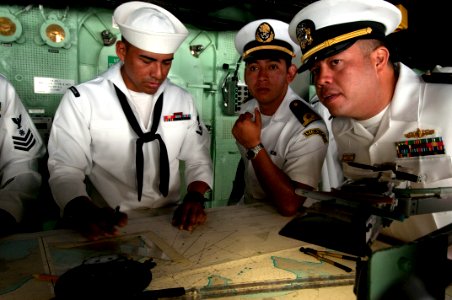 US Navy 100615-N-5319A-002 Quartermaster 3rd Class Daniel Urbano, left, keeps track of the ship's position as Mexican navy Lt. Navarrete and Lt.j.g. Jonathan Seawert watch on the bridge of the amphibious transport dock ship USS