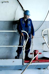 US Navy 100617-N-6477M-636 Seaman Stephen Olson waits to throw lines to a landing craft utility aboard the amphibious transport dock ship USS Cleveland (LPD 7)