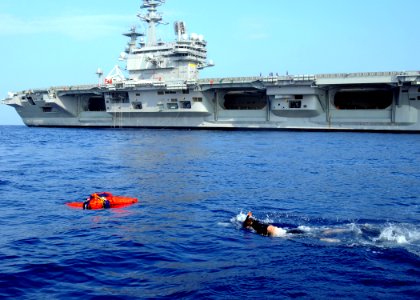 US Navy 100615-N-7908T-748 Search and rescue swimmer Interior Communications Electrician 2nd Class Brandon E. Fox swims to Oscar during a man overboard rescue drill
