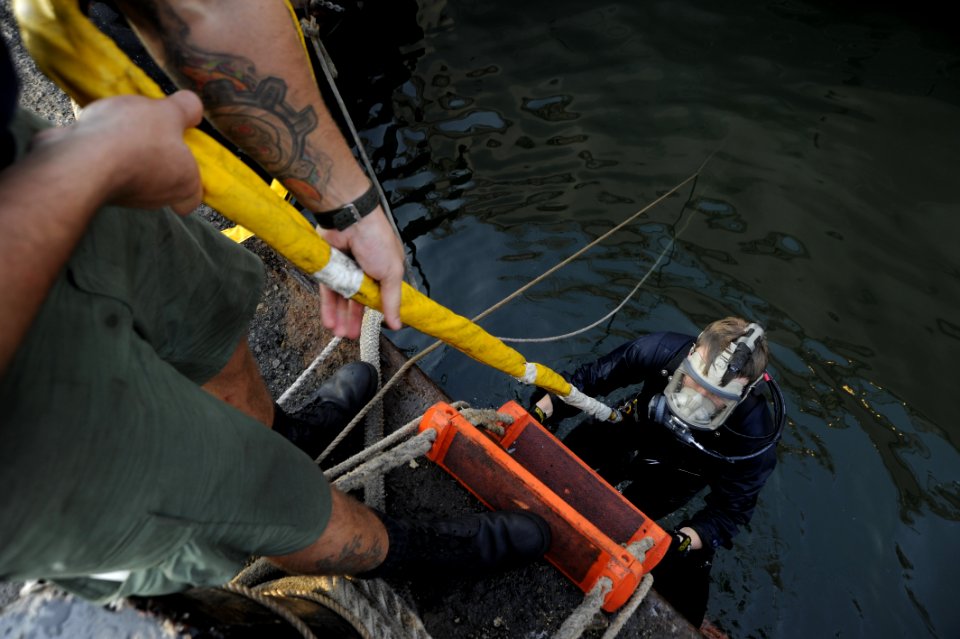 US Navy 100616-N-4776G-503 Navy Diver 1st Class Justin Cavitt ascends from the water after working under USS The Sullivans (DDG 68) to change damaged controllable pitch propeller blades