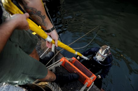 US Navy 100616-N-4776G-503 Navy Diver 1st Class Justin Cavitt ascends from the water after working under USS The Sullivans (DDG 68) to change damaged controllable pitch propeller blades