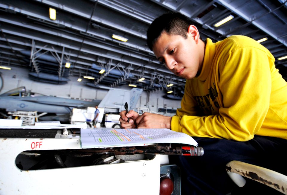 US Navy 100616-N-6003P-098 Aviation Boatswain's Mate (Handling) 3rd Class Ray Amaya, studies for his Enlisted Aviation Warfare Specialist exam during a break aboard the Nimitz-class aircraft carrier USS Harry S. Truman (CVN 75)