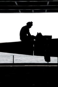 US Navy 100619-N-7605J-099 Cpl. Jacob Osorio, assigned to the Death Rattlers of Marine Strike Fighter Squadron (VMFA) 323, replaces an electrical drive unit on an F-A-18 Hornet aboard the aircraft carrier USS Ronald Reagan (CVN