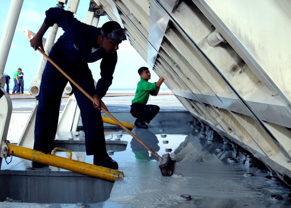 US Navy 100619-N-6632S-056 ATLANTIC OCEAN (June 19, 2010) Aviation Boatswain's Mate (Equipment) Airman Demitrius Smith scrubs underneath a jet blast deflector