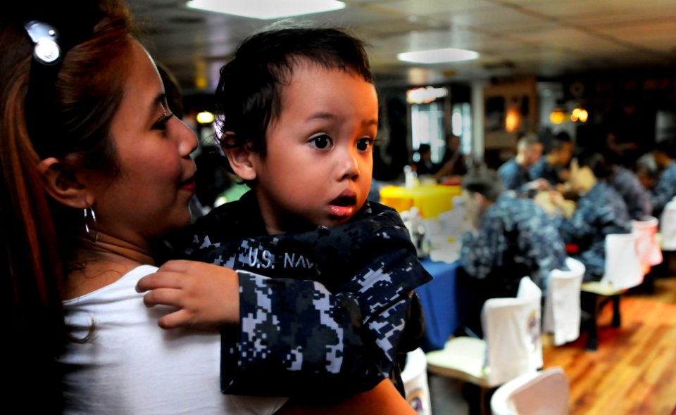 US Navy 100618-N-5716H-061 A child looks at his father, Culinary Specialist 2nd Class Rowin Lameque, during a Father's Day celebration lunch aboard the U.S. 7th Fleet command ship USS Blue Ridge (LCC 19)