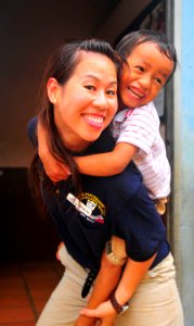 US Navy 100617-N-6597H-437 Mannhu Bui gives a piggy-back ride to a Cambodian child