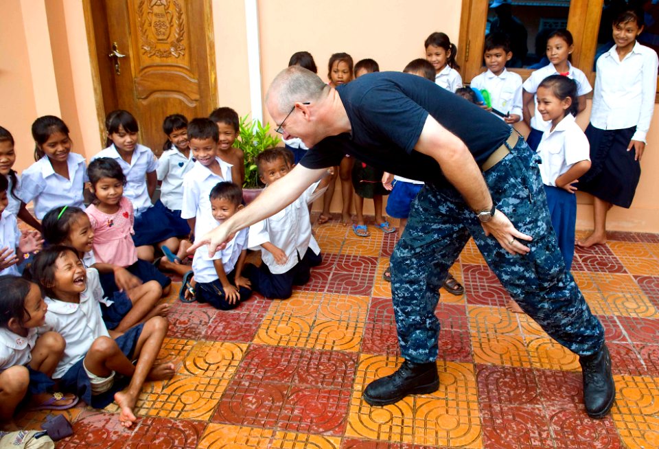 US Navy 100620-N-6410J-146 Lt. Derrick Horne points at a girl while playing a game during a community service event at Enfants du Cambodge orphanage in Sihanoukville, Cambodia