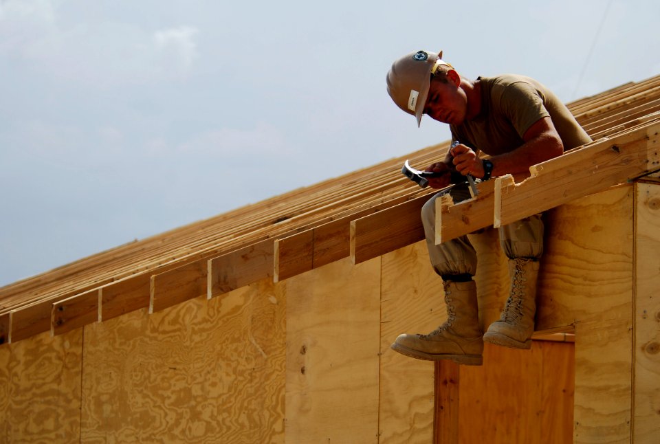 US Navy 100616-N-6538W-065 Builder 3rd Class Garrett O'Brien chisels out notches for a roof at a forward outpost in Kunduz, Afghanistan