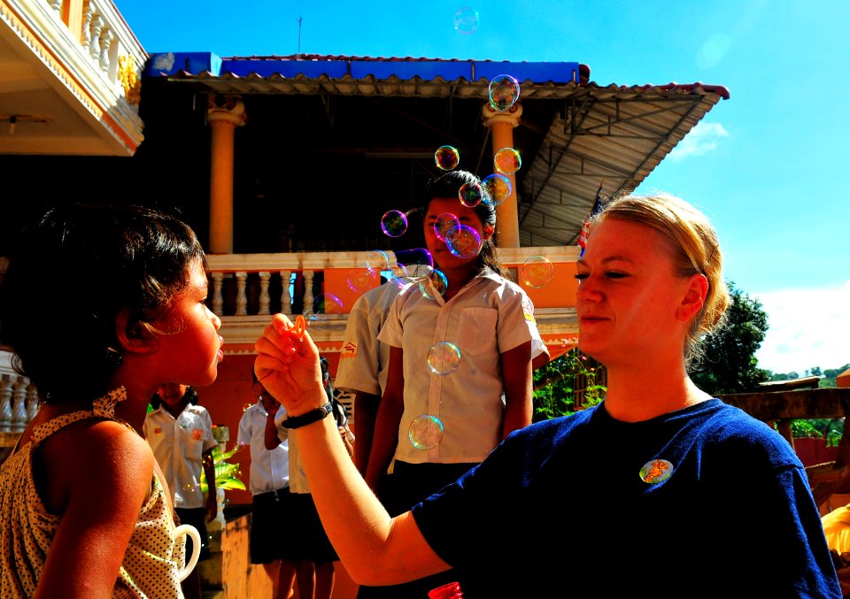 US Navy 100620-N-6597H-268 Aerographer's Mate 3rd Class Brooke Belvins blows bubbles with Cambodian children during a Pacific Partnership 2010 community service event at the Enfants du Cambodge orphanage