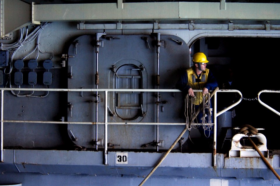 US Navy 100617-N-6477M-639 Boatswain's Mate 3rd Class David Backer waits to throw lines to a landing craft utility aboard the amphibious transport dock ship USS Cleveland (LPD 7)