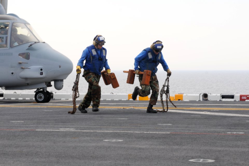 US Navy 100617-N-3852A-044 Airmen remove the chocks and chains from a Marine Corps V-22 Osprey aircraft during flight deck operations aboard the amphibious assault ship USS Wasp (LHD 1)