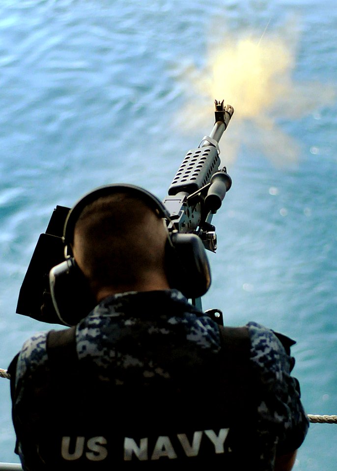 US Navy 100619-N-8913A-184 Master-at-Arms 2nd Class Donald W. Livingston, assigned to the aircraft carrier USS George H.W. Bush (CVN 77), fires an M-240 machine gun on the ship's fantail