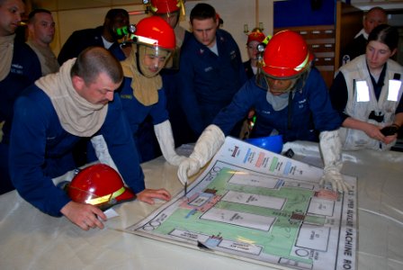 US Navy 100618-N-2653R-071 U.S. Sailors map out simulated damages on a diagram of the upper auxiliary machinery room aboard the Royal Navy frigate HMS Sutherland (F81)