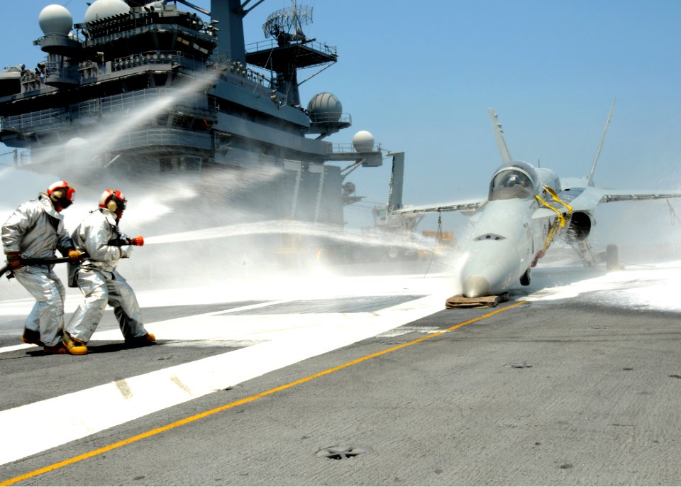 US Navy 100621-N-7908T-073 Air department Sailors assigned to the crash and salvage division of the aircraft carrier USS George H.W. Bush (CVN 77) spray water on an F-A-18 Hornet training aircraft
