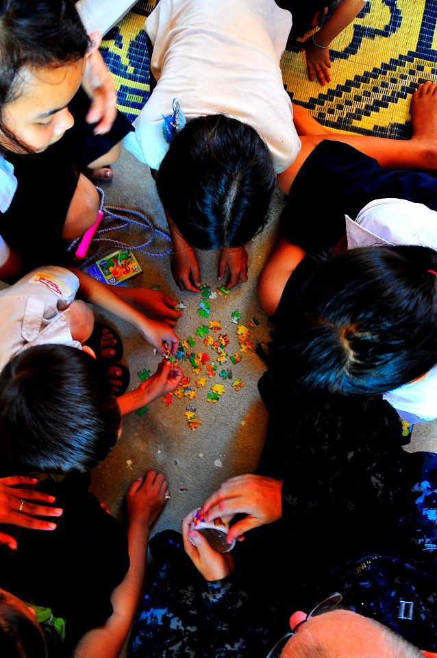US Navy 100620-N-6597H-142 Lt. Derrick Horne helps Cambodian children put a puzzle together during a Pacific Partnership 2010 community service event at the Enfants du Cambodge orphanage