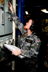 US Navy 100618-O-8247T-080 Royal Australian Navy Seaman Marine Technician Vikki Howe, from Moora, Australia, checks pressures on a diesel generator in enclosed operating station 1