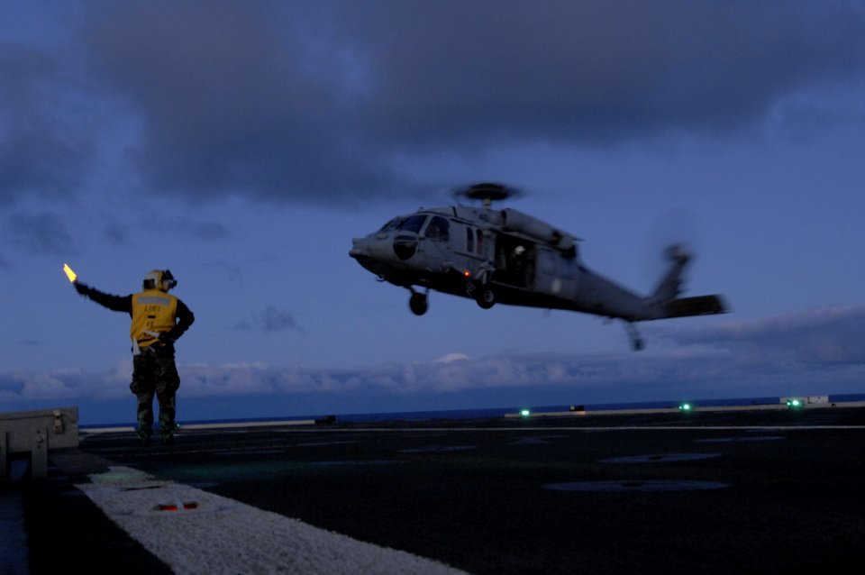 US Navy 100619-N-6477M-880 Aviation Boatswain's Mate (Handling) 2nd Class Gerson Gonzales launches an SH-60 Sea Hawk helicopter from USS Cleveland (LPD 7)