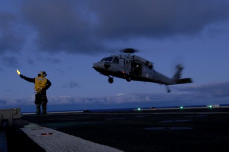 US Navy 100619-N-6477M-880 Aviation Boatswain's Mate (Handling) 2nd Class Gerson Gonzales launches an SH-60 Sea Hawk helicopter from USS Cleveland (LPD 7) photo