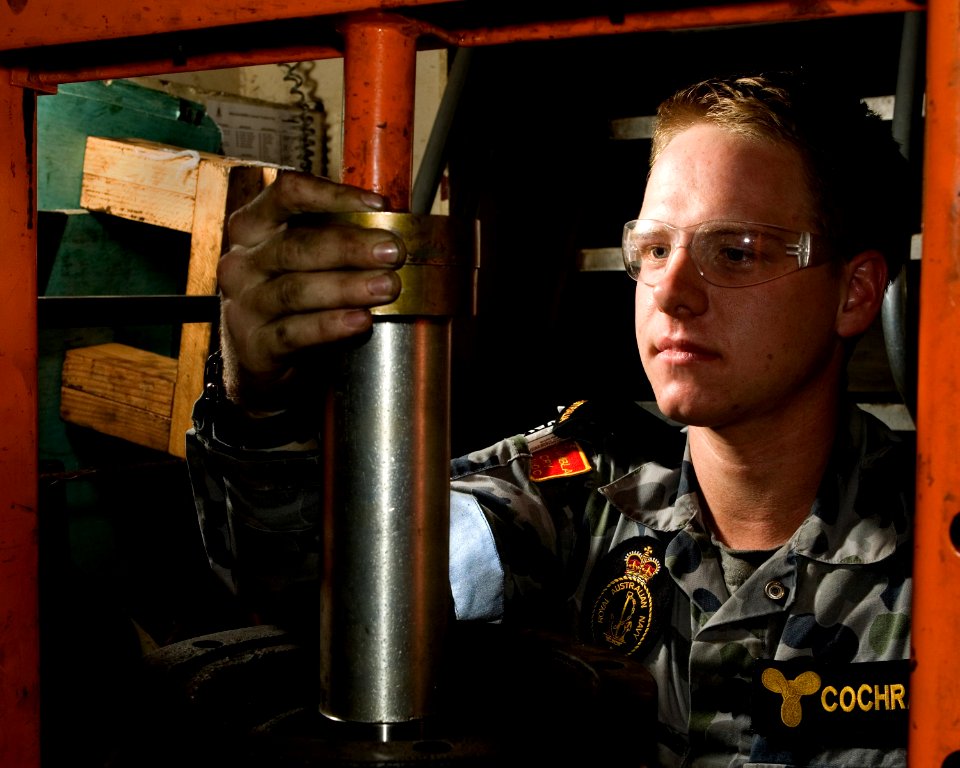 US Navy 100619-O-8247T-015 Royal Australian Navy Seaman Marine Technician Josh Cochrane from Sydney, Australia, seats a new bearing into a refurbished water pump aboard the Royal Australian Navy amphibious landing platform HMAS
