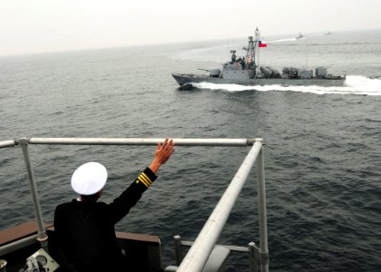 US Navy 100619-N-9301W-619 Cmdr. Scott Smith, commanding officer of the guided-missile frigate USS Klakring (FFG 42), waves as the Chilean navy fast attack craft Serrano (LM 38) passes by after Klakring rendered honors to Chile