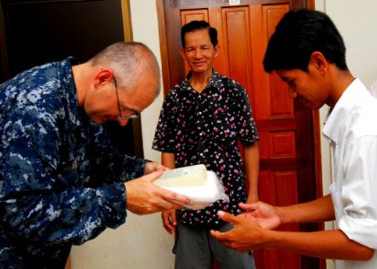 US Navy 100623-N-4044H-209 Lt. Derrick Horne, a Navy chaplain embarked aboard the Military Sealift Command hospital ship USNS Mercy (T-AH 19), gives a hygiene kit, assembled by Latter-day Saint Charities, to a shelter member du