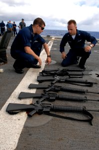 US Navy 100621-N-6477M-069 Fire Controlman 2nd Class Stephen Solimine, left, and Gunner's Mate 3rd Class Jonathan Kedzierski prepare M-16 rifles for weapons training