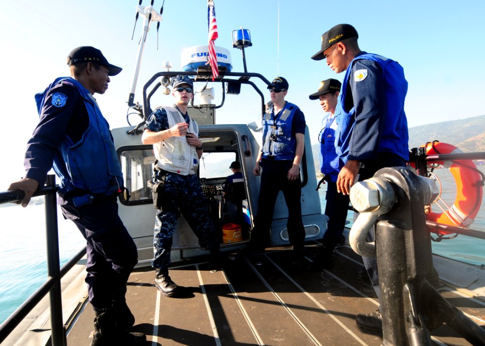 US Navy 100622-N-3729D-004 Ensign Dustin Holm, center left, and Engineman 3rd Class Christopher Johnson, center right, explain common patrol procedures to members of the Dili Maritime Police