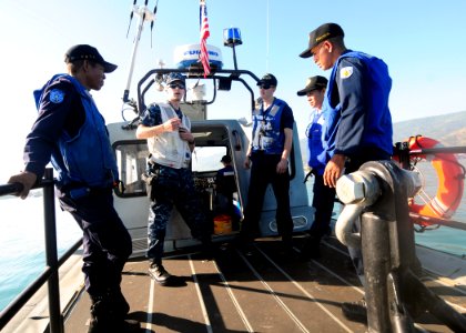 US Navy 100622-N-3729D-004 Ensign Dustin Holm, center left, and Engineman 3rd Class Christopher Johnson, center right, explain common patrol procedures to members of the Dili Maritime Police
