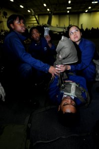 US Navy 100621-N-9132C-079 Stretcher bearers render medical aide to a casualty during a general quarters drill in the hangar bay of the aircraft carrier USS Ronald Reagan (CVN 76)