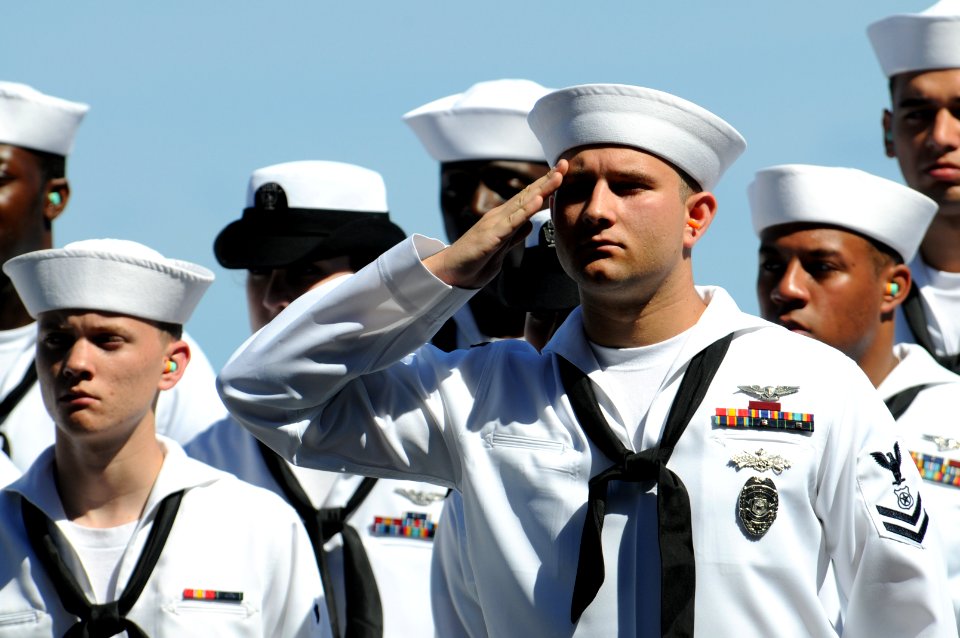 US Navy 100622-N-9132C-349 Master-at-Arms 2nd Class Joseph Churan alutes as remains of military personnel are laid to rest at sea during a burial at sea ceremony