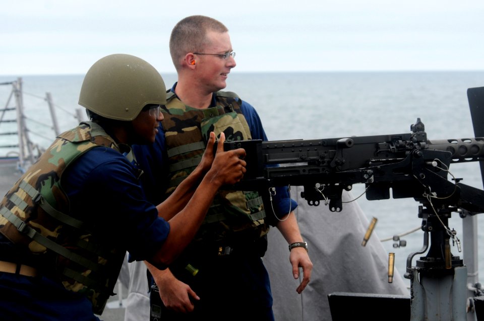 US Navy 100623-N-0775Y-053 Gunner's Mate 1st Class Dylan Lay, from Borger, Texas, coaches a midshipman during a live-fire exercise aboard the guided-missile destroyer USS Sterett (DDG 104)