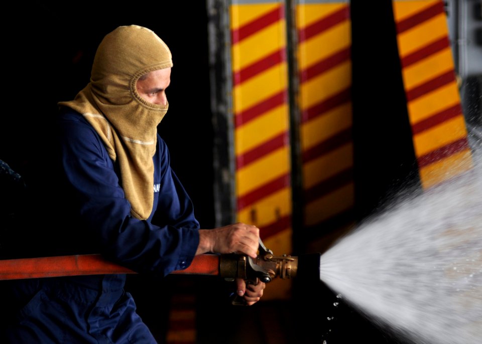 US Navy 100623-N-2013O-027 Aviation Structural Mechanic 3rd Class Edgar Rojasberrio, from Bogota, Colombia, uses a fire hose during a general quarters drill