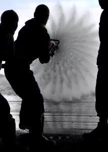 US Navy 100623-N-2013O-051 Aviation Electronics Technician Michael Kaltsunas, from Boston, uses a fire hose during a general quarters drill aboard the aircraft carrier USS George Washington (CVN 73)