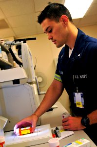 US Navy 100623-N-7364R-005 Hospital Corpsman 3rd Class John McCallum prepares a prescription by using a telepharmacing system at the Naval Support Activity (NSA) Capodichino branch clinic photo