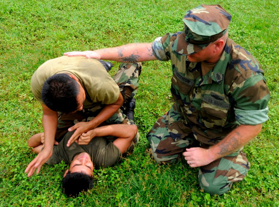 US Navy 100625-N-9643W-448 Senior Chief Gunner's Mate Edward Middendorf, from New York, explains basic takedown techniques to El Salvadorian sailor